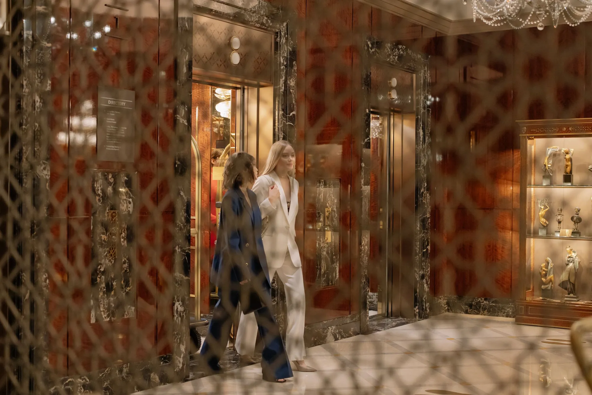Guests crossing a hotel lobby toward the elevators