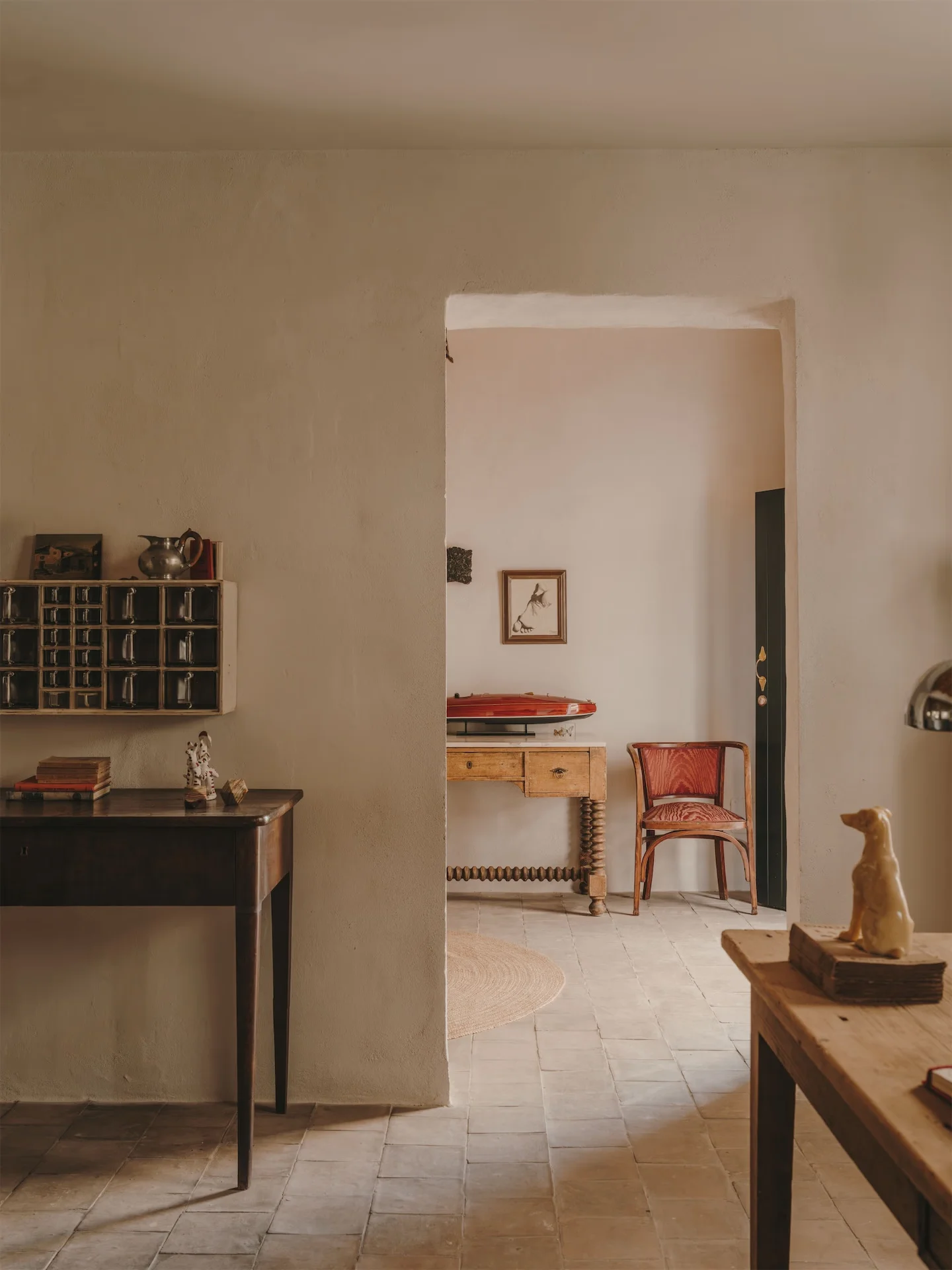 A quiet hotel interior: a writing desk and a doorway into the next room